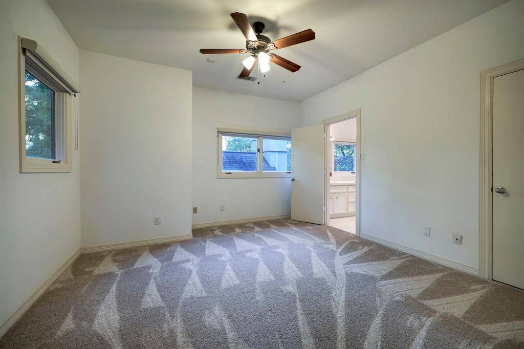 The large secondary bedroom 2 with carpet floors and two full-lite windows.