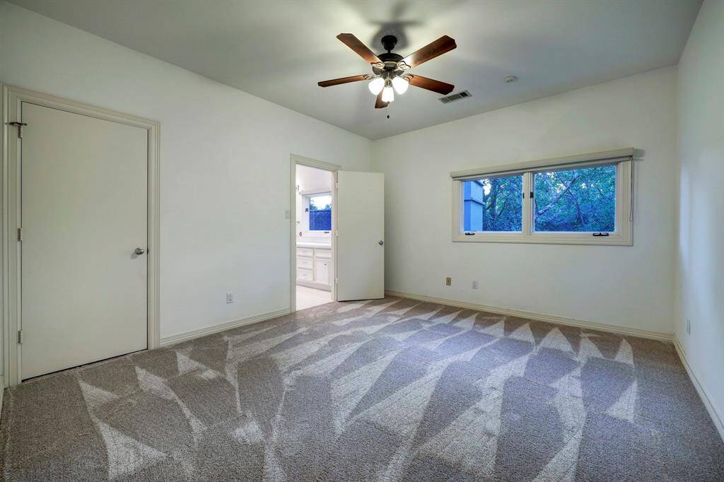 Bedroom 3 with two full-lite windows with custom shades and carpet floors.