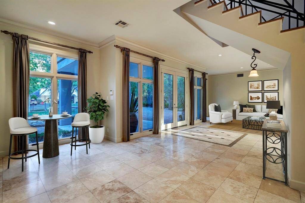 Virtually staged photo of the foyer and formal living room.
