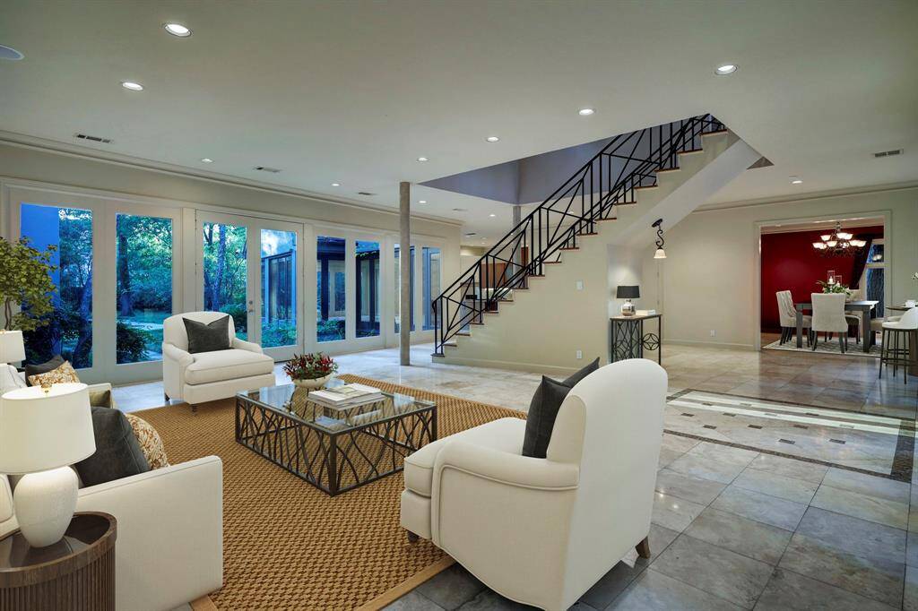 Virtually staged photo of the foyer and formal living room. Shows access to the adjacent dining room.