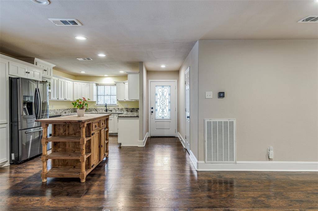 View of the front entry and kitchen located to the left.