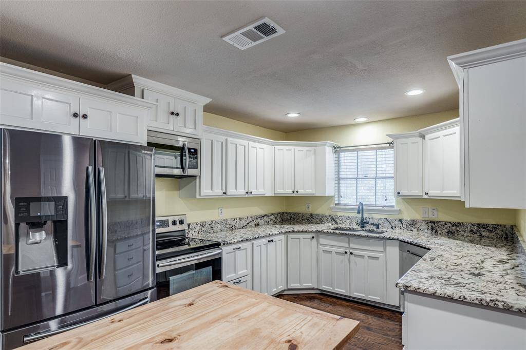 Beautifully updated kithchen featuring granite countertops, stainless steel appliances, and lots of storage space. BUYER BONUS...FRIDGE STAYS WITH THE HOME!