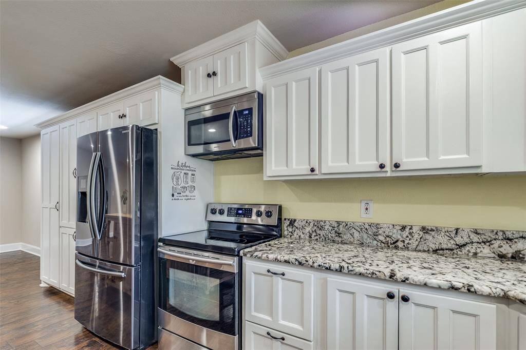 Another view of the kitchen picturing more storage on the other side of the fridge.