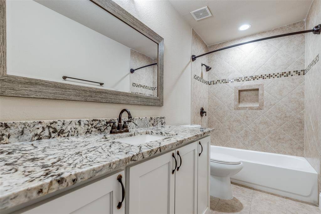 Beautifully updated 1 of 2 secondary bathrooms. Granite countertops, framed mirror, & updated cabinetry.