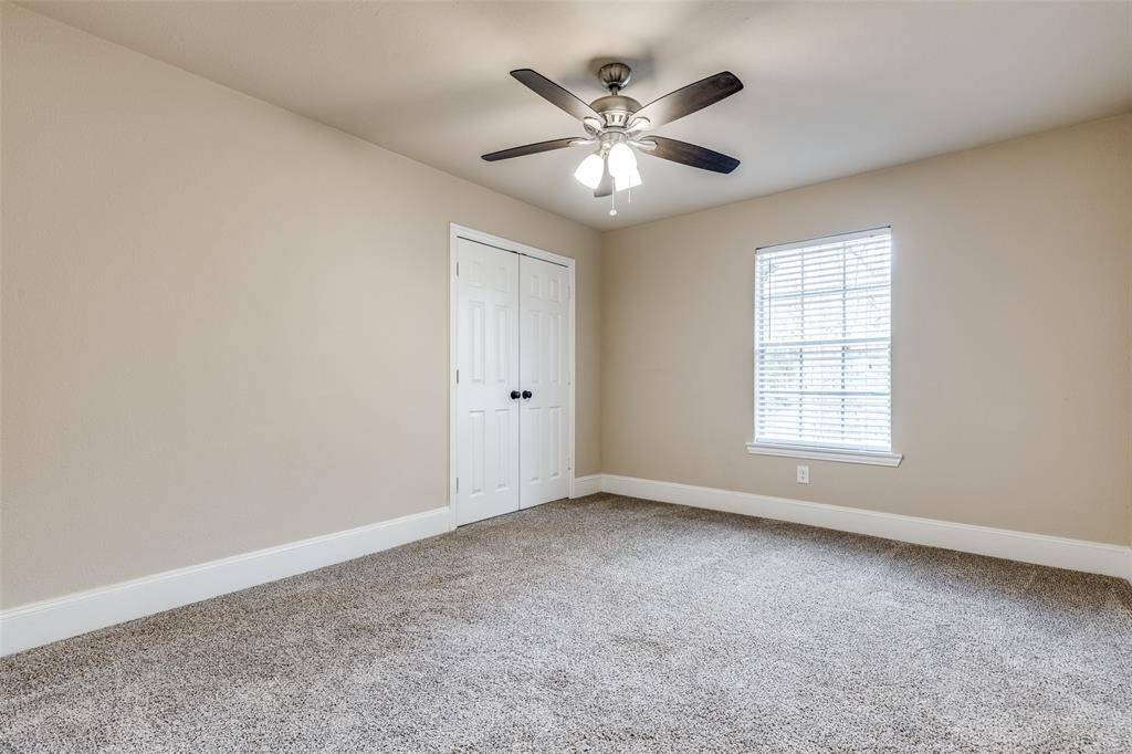 Secondary Bedroom # 1 with ceiling fan and built-in storage/shelving in the closet