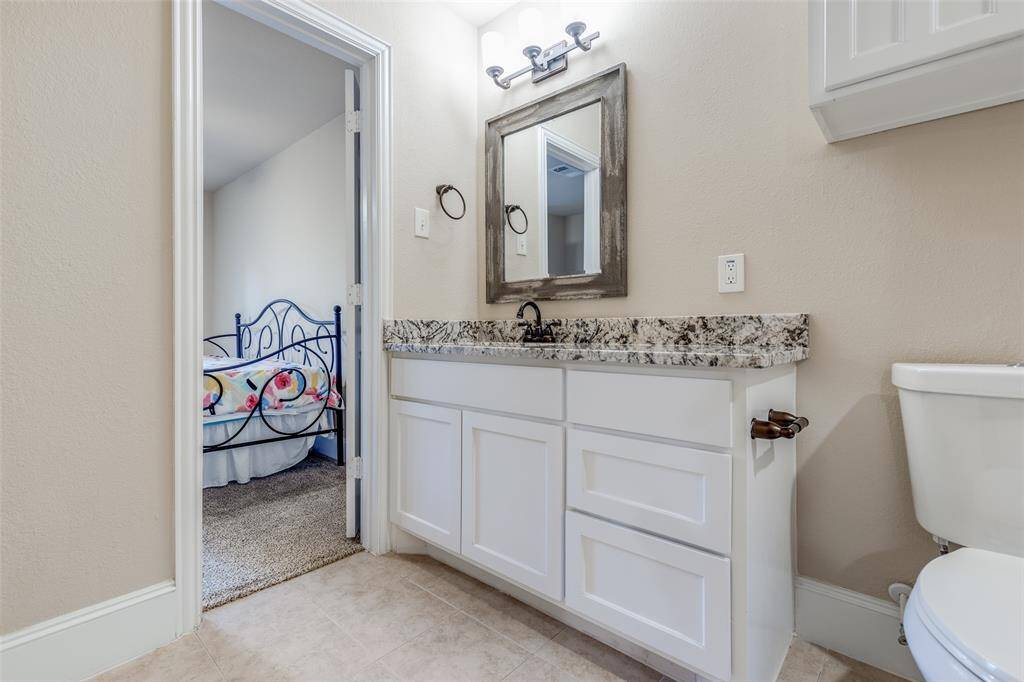 Jack and Jill Bathroom. Updated vanity, framed mirror, granite countertops.