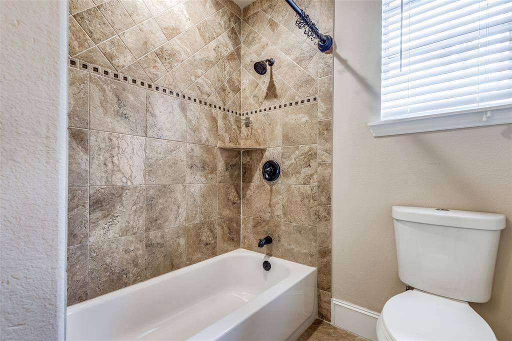 Primary Bathroom with shower/tub combo and Window letting in natural light.