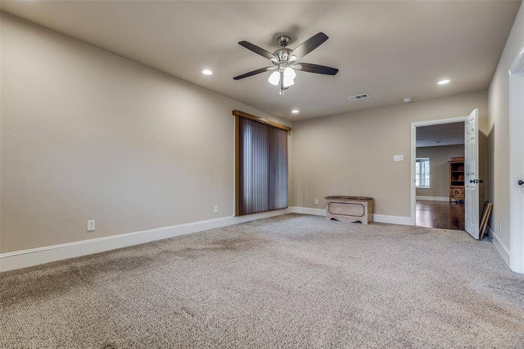Primary bedroom located off of the family room. Access to the screened in patio through the sliding glass doors pictured on the left.