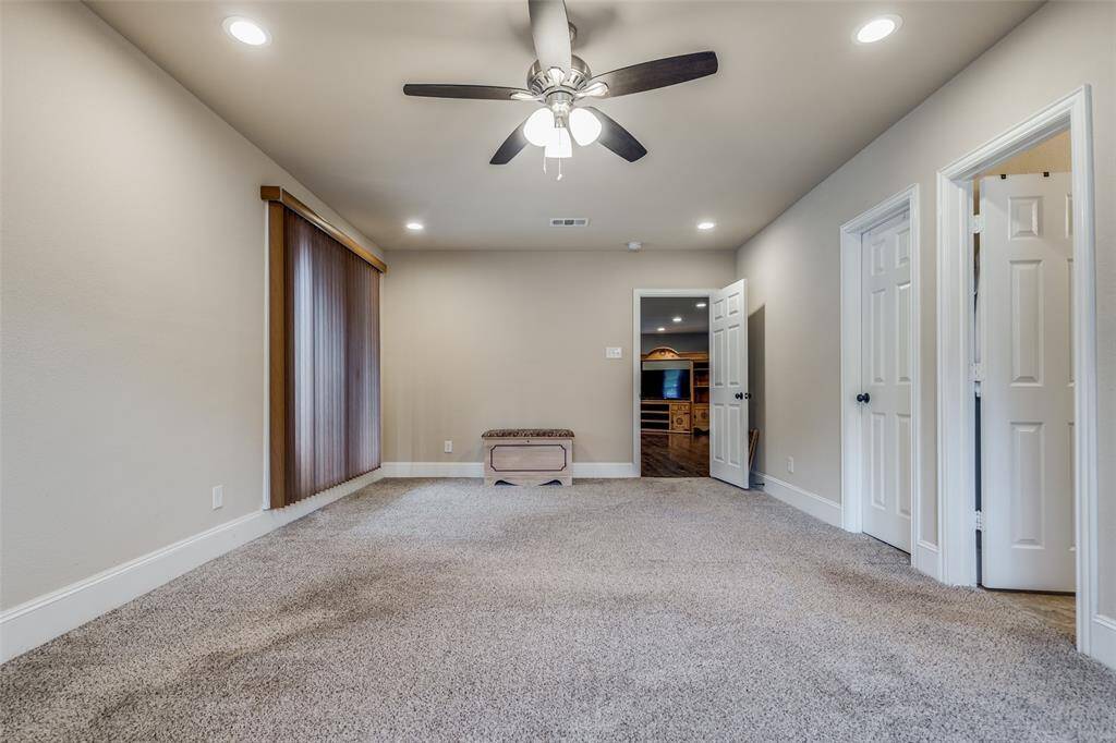 Primary bedroom with ceiling fan, walk in closet with built in storage/shelving, and BUYER BONUS- gun cabinet (not pictured) stays with the home.
