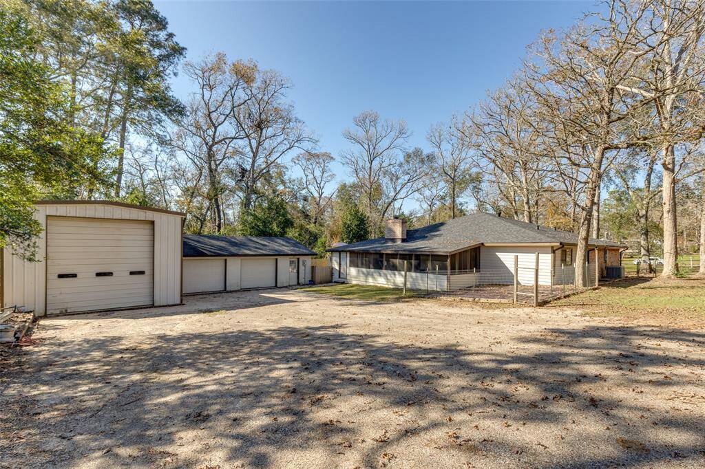 Exterior view of the shop, 2 car garage, and screened in patio. All located behind the home.