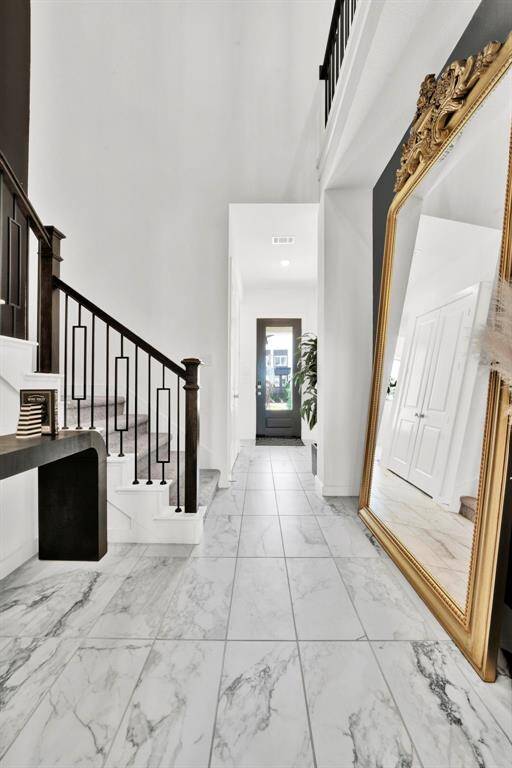 Designer staircase features extended iron spindles for a touch of architectural artistry.