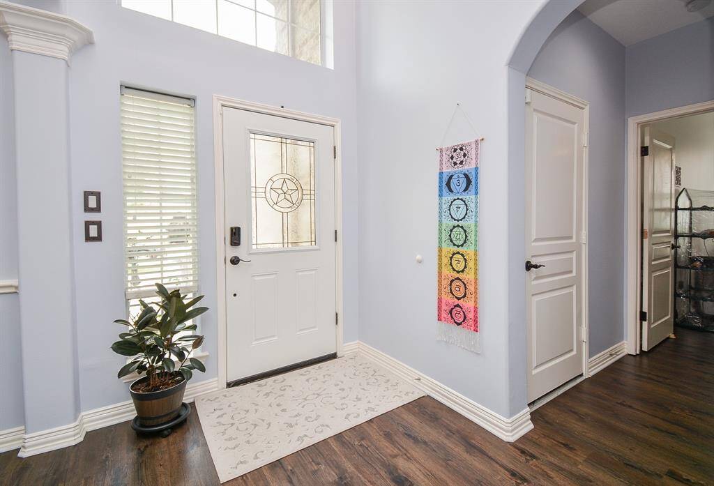 This is the wonderful view of your front entry, from the inside; bathed in neat, neutral tones, with durable, gorgeous, darker wood-look laminate flooring.