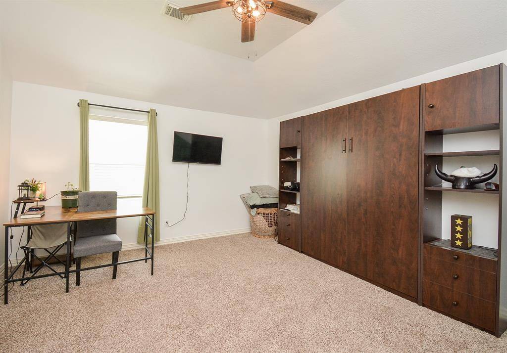 As suggested here, a trim home office is perfect in this generous 'flex' room space. (Note the size of the wall-wide storage/display unit!)