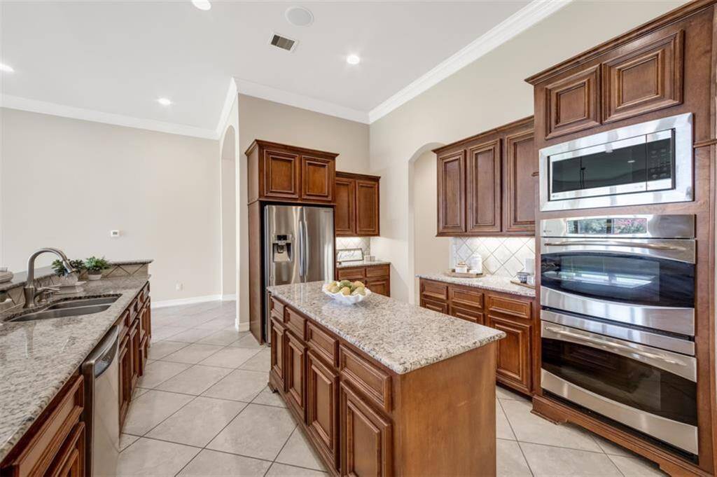 The kitchen is as functional as it is beautiful, with a tile backsplash laid on the diagonal adding a modern touch. Stainless steel appliances complement the gorgeous cabinets and granite counters while a double basin sink makes clean-up a breeze.