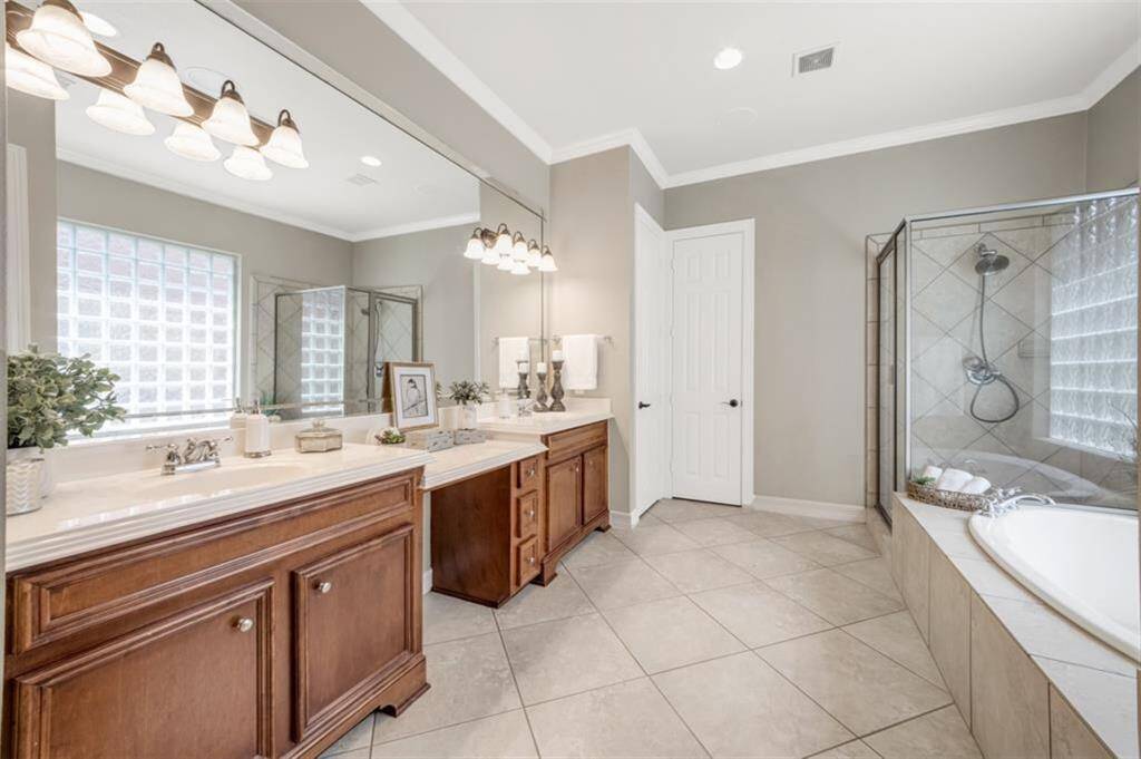 Another view of the ensuite bathroom with tile flooring laid on the diagonal, recessed lighting and oversized mirror.