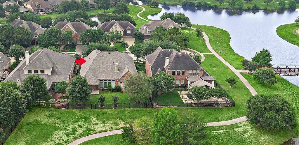 Check out this aerial showing the lake that wraps around the cul-de-sac location of this home. What a great way to get your steps in just off your back patio.
