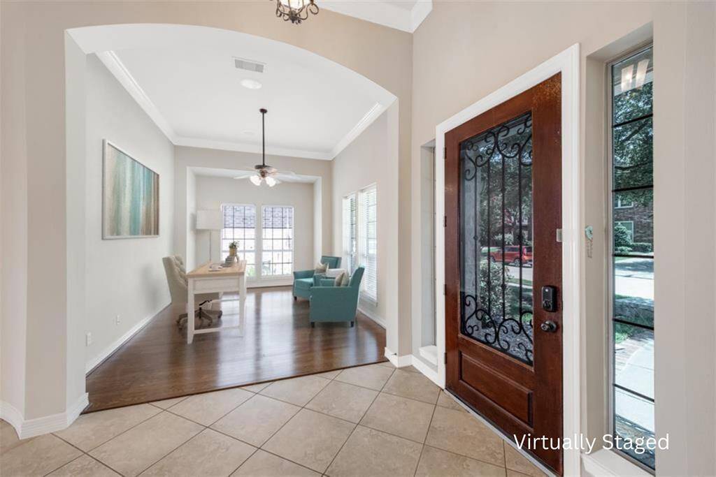 Step inside and you are welcomed by a beautiful entryway with tiled flooring laid on the diagonal. The rich mahogany door, adorned with iron accents is flanked by accent windows on either side allowing natural light to flow through.