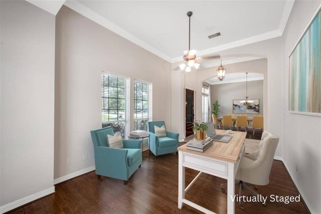 On the other side of the entry, you'll find the perfect space for a home office or a second living area. This bright and inviting space features windows on two walls, allowing natural light to fill the room. Finished with blinds for privacy, high ceilings, and beautiful wood flooring, this room offers a comfortable and elegant retreat for work or relaxation.