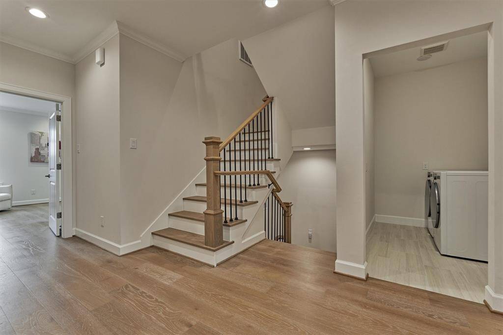 Second level landing showcases wood treads and continuous hardwoods throughout.