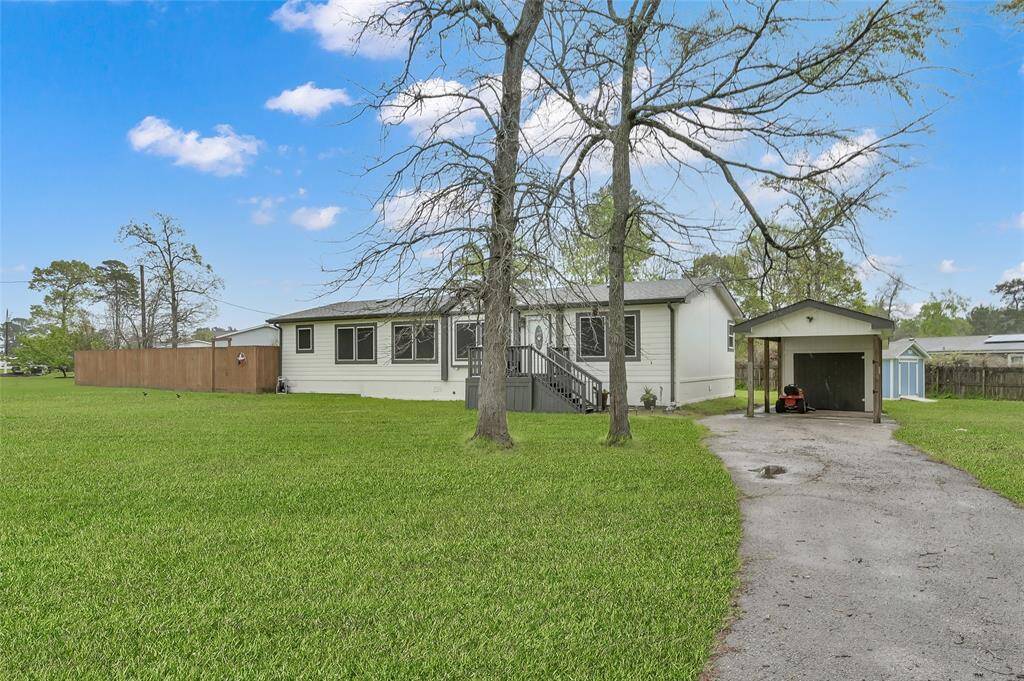 Long driveway with covered parking and storage shed.