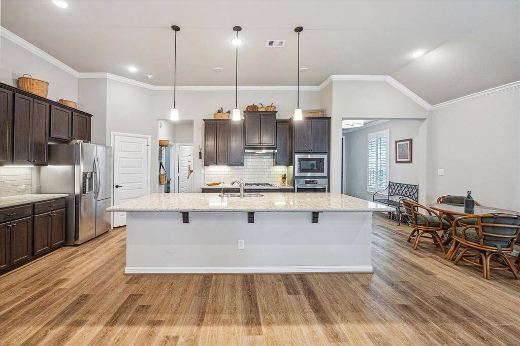 Great view of the huge island and how attractive the space truly is for your enjoyment. The crown molding sets off the neutral paint walls and the five panel doors are another feature.