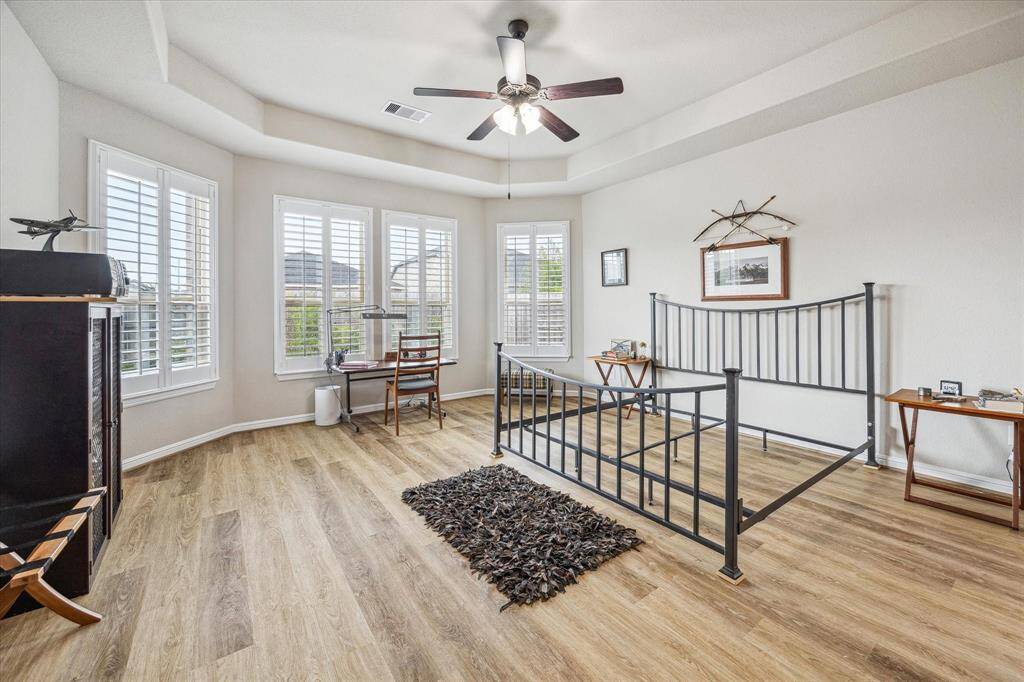 Primary Suite features tray ceiling, extended triple bay window, beautiful floors and very spacious.