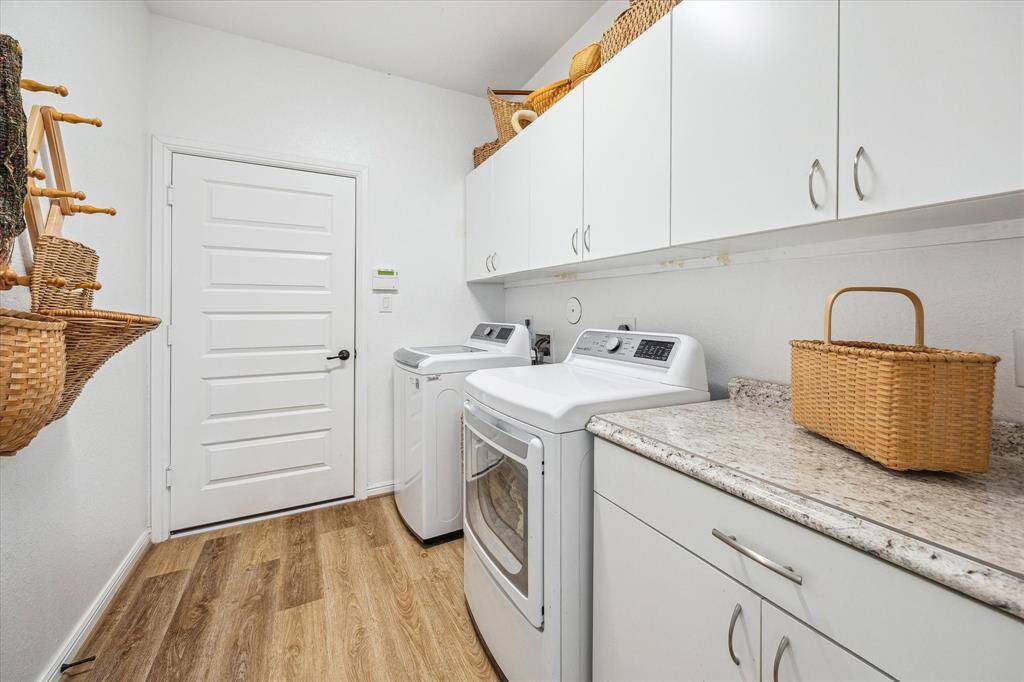 The laundry area has a full wall of white cabinets and opens to the garage to make bringing in groceries very easy.