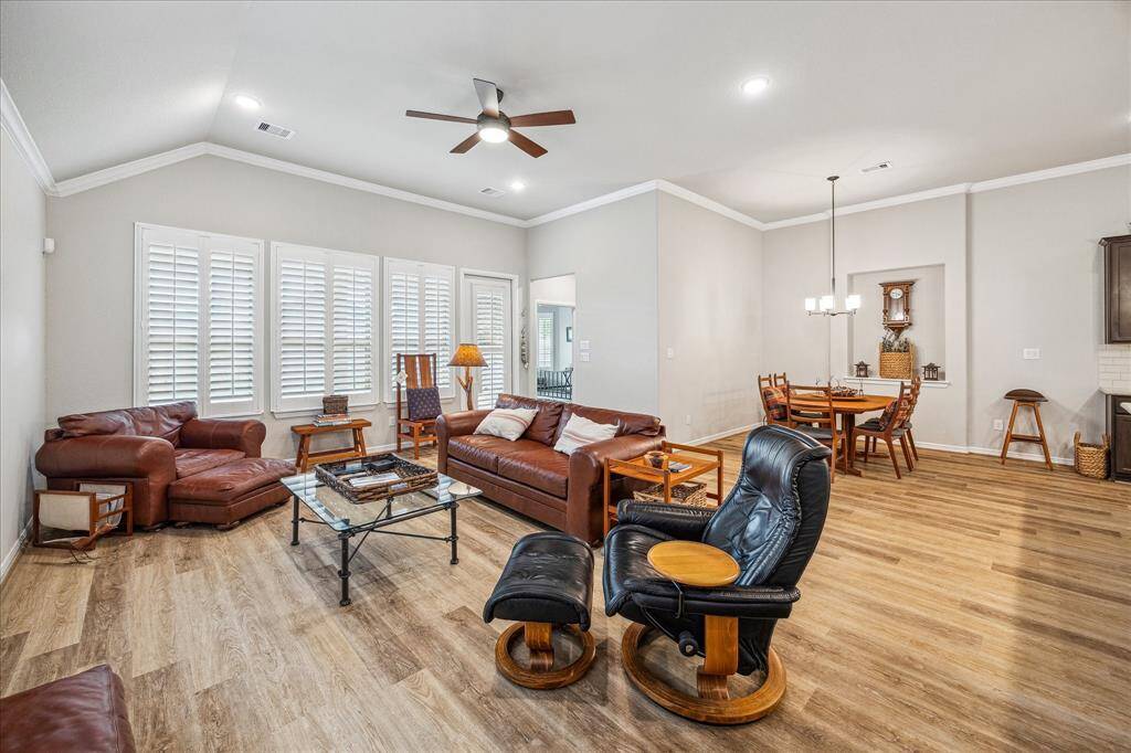 The back wall of the Living area is full of windows and are richly appointed with white Planation shutters.  The open concept living includes the dining area with art niche.