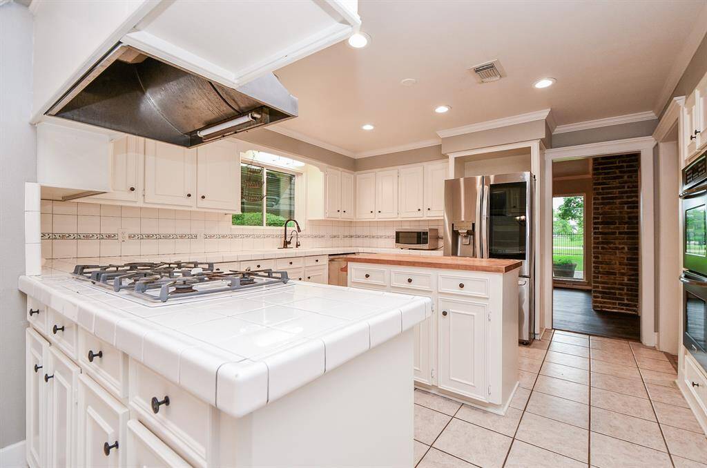 Large kitchen with the popular white cabinets.   Gas cooktop and island without a cooktop