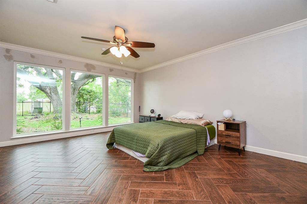 Primary bedroom is on the first floor.  Beautiful wood look tile, and yes, more of these floor to ceiling windows