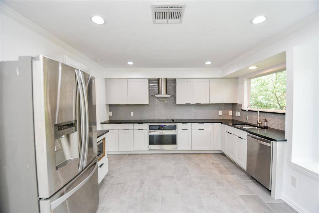 The refrigerator stays!  The kitchen has been totally remodeled and features quartz counters, stainless appliances, glass subway tile backsplash and recessed lighting.