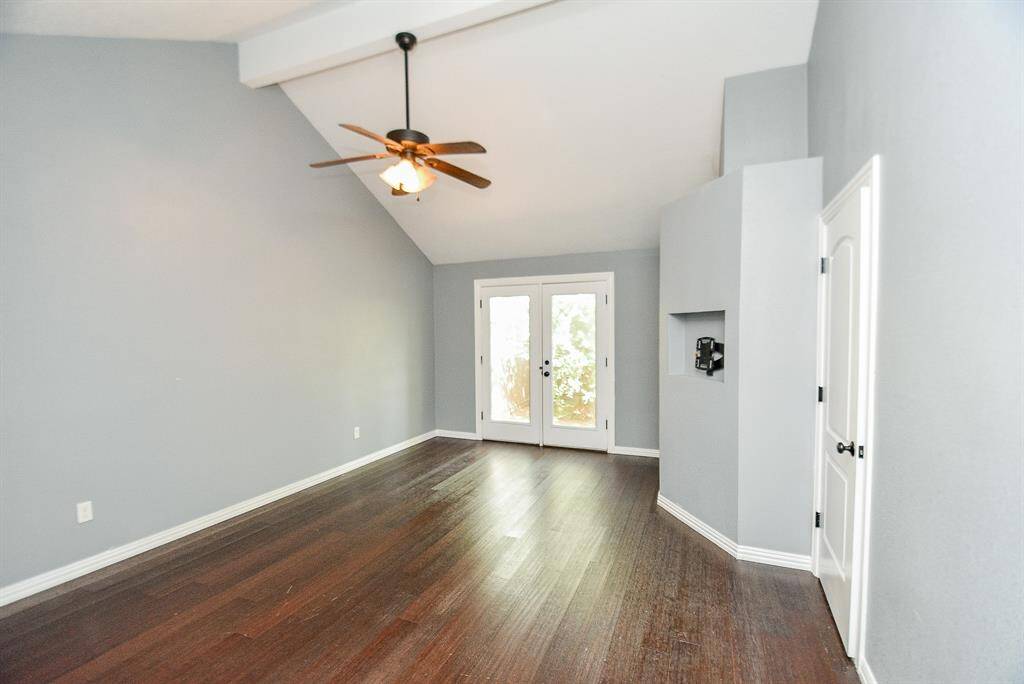 The Primary Bedroom has very high ceilings and is in the back of the house - tons of space, including a nice sitting area with french doors that lead to the back yard area.