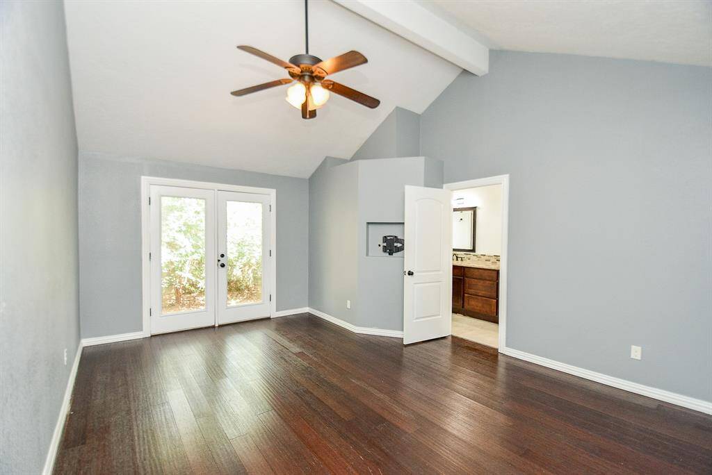 Another view of the Primary Bedroom also shows the beam in the ceiling & ceiling fan to stay cool while you sleep.