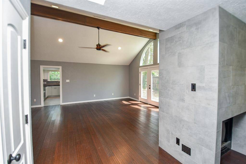 The Living Room features soaring ceilings with a wood beam.  The 2 sided fireplace is in this area too.