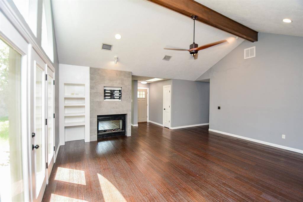 Another view back towards the front door shows the 2 sided fireplace with more built in shelving.