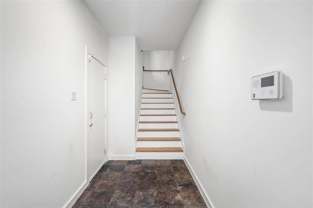 Bright entryway featuring sleek stairs and easy access to upstairs treasures.