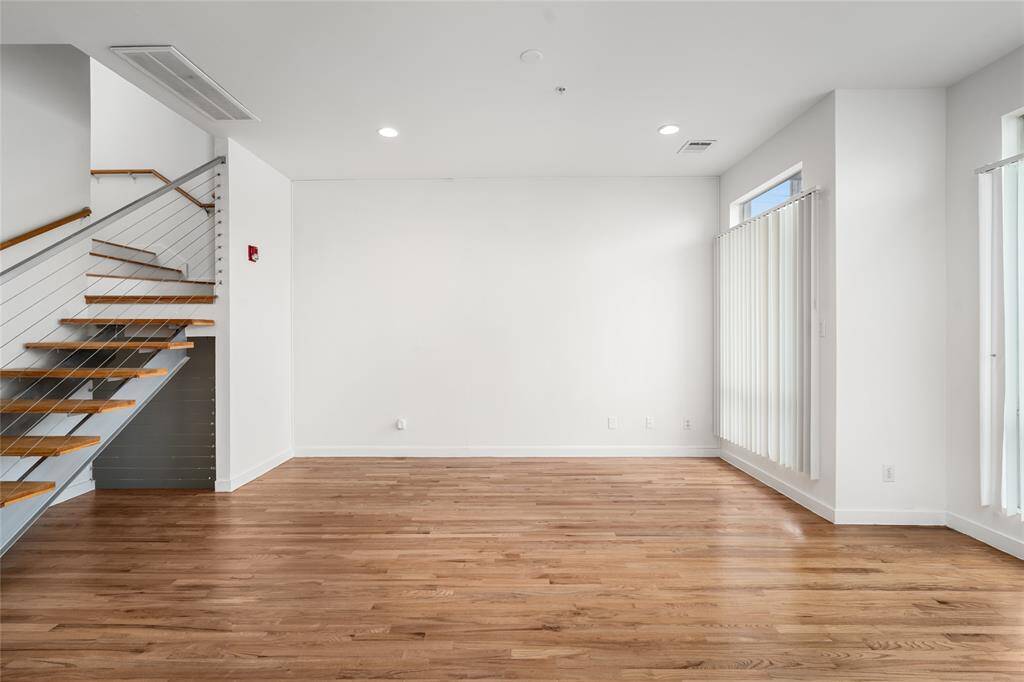 Bright and airy living area with expansive floor-to-ceiling windows, allowing natural light to fill the space and create a welcoming, open ambiance.
