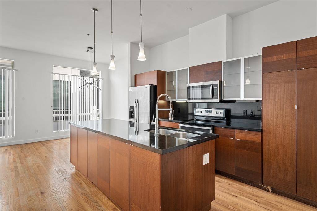 Well-appointed kitchen featuring stainless steel appliances, a spacious island with a sink, and plenty of counter space, perfect for cooking and entertaining.