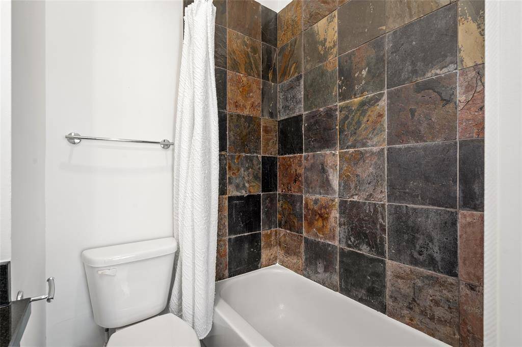 Stylish secondary bathroom featuring a unique glass sink, adding a modern touch and creating an elegant, contemporary look.