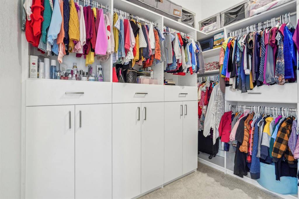Custom built cabinets and storage in a spacious walk in closet.