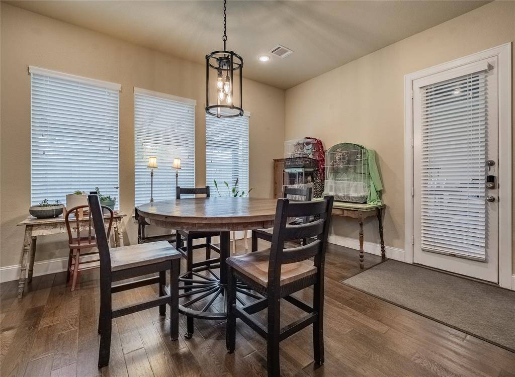 from this view of the breakfast nook you see the back door leading to the covered patio and large backyard
