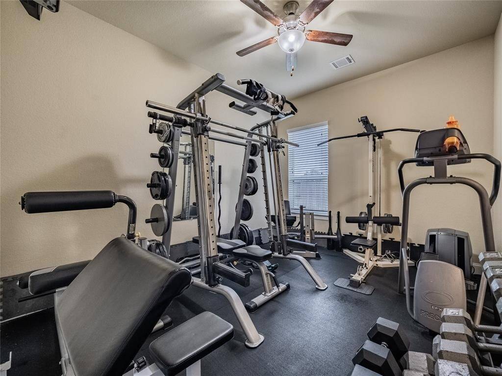 bedroom being used as a weight room has wooden floors underneath the padding on the floor at this time shares a jack/jill bath