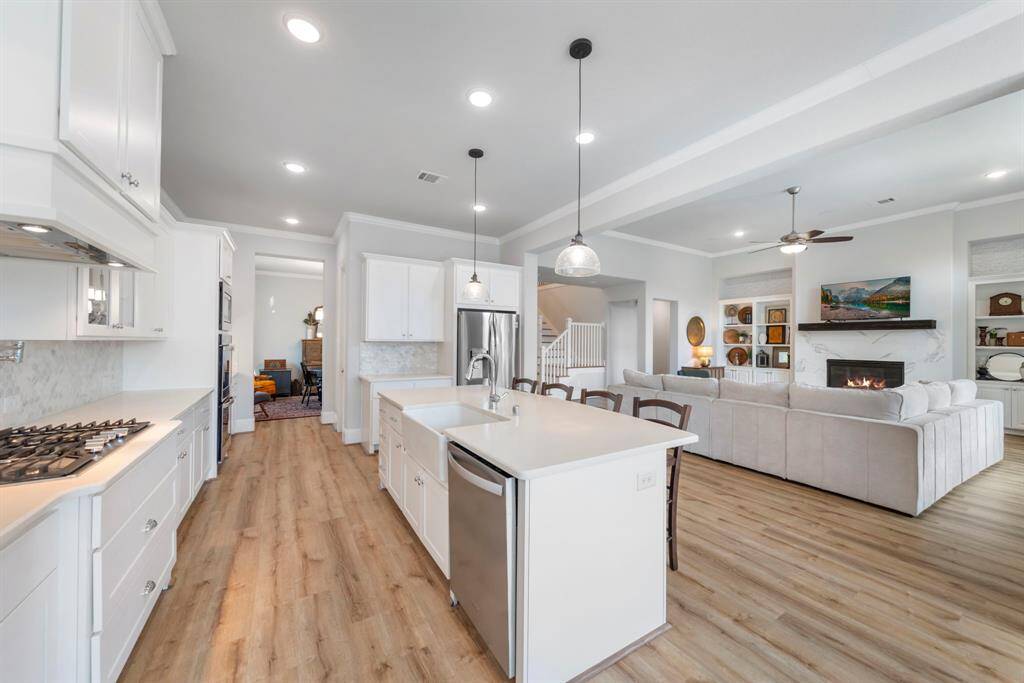 Centrally located kitchen offers abundant counter space, a perfect coffee bar, and a butler’s pantry/dry bar—ideal for entertaining. The open-concept design ensures a seamless flow between the living and dining areas.