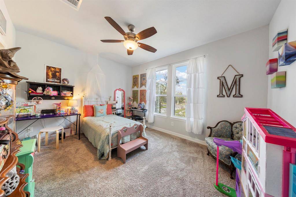 Second-floor bedroom boasts cozy carpeting, plenty of natural light, and an ensuite bath with a walk-in closet.