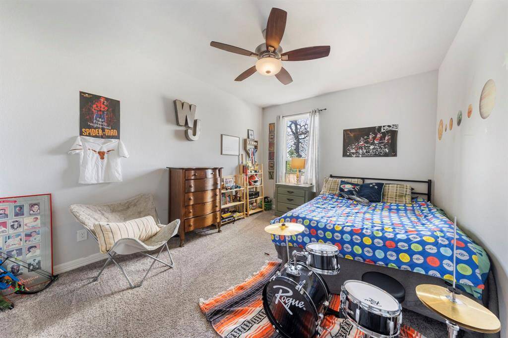 Second-floor bedroom features cozy carpeting, a walk-in closet, ceiling fan, and plenty of natural light.