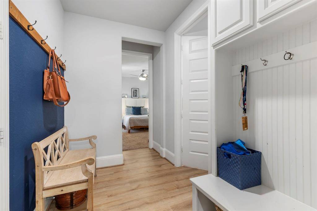 Mudroom at garage entry, featuring storage cabinets and a seat for easy shoe removal.