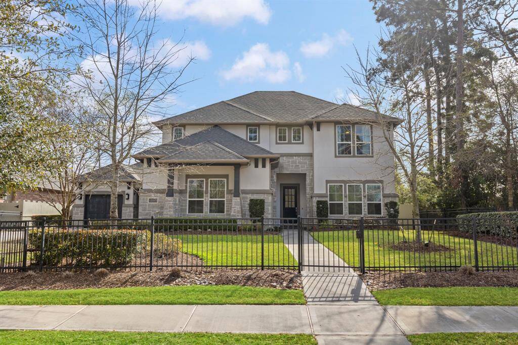 Elegant stucco and stone exterior on a premium corner lot in Harper’s Preserve, featuring a private gated driveway.