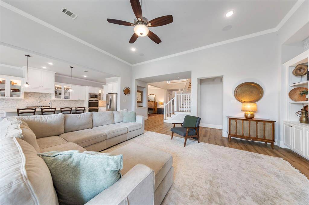 Bright and inviting living area with high ceilings, elegant crown molding, and an open-concept design with semaless transition to the gourmet kitchen.