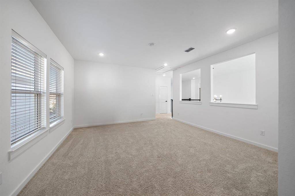 Plush carpeting and recessed lighting enhance the intimate atmosphere in this space, perfect for game nights or casual gatherings.