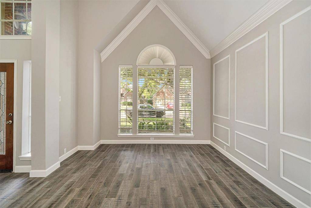 The formal living room has a fantastic appeal that makes you want to sit and stay awhile, with its arched window, crown molding, and box molding, giving it a timeless look!